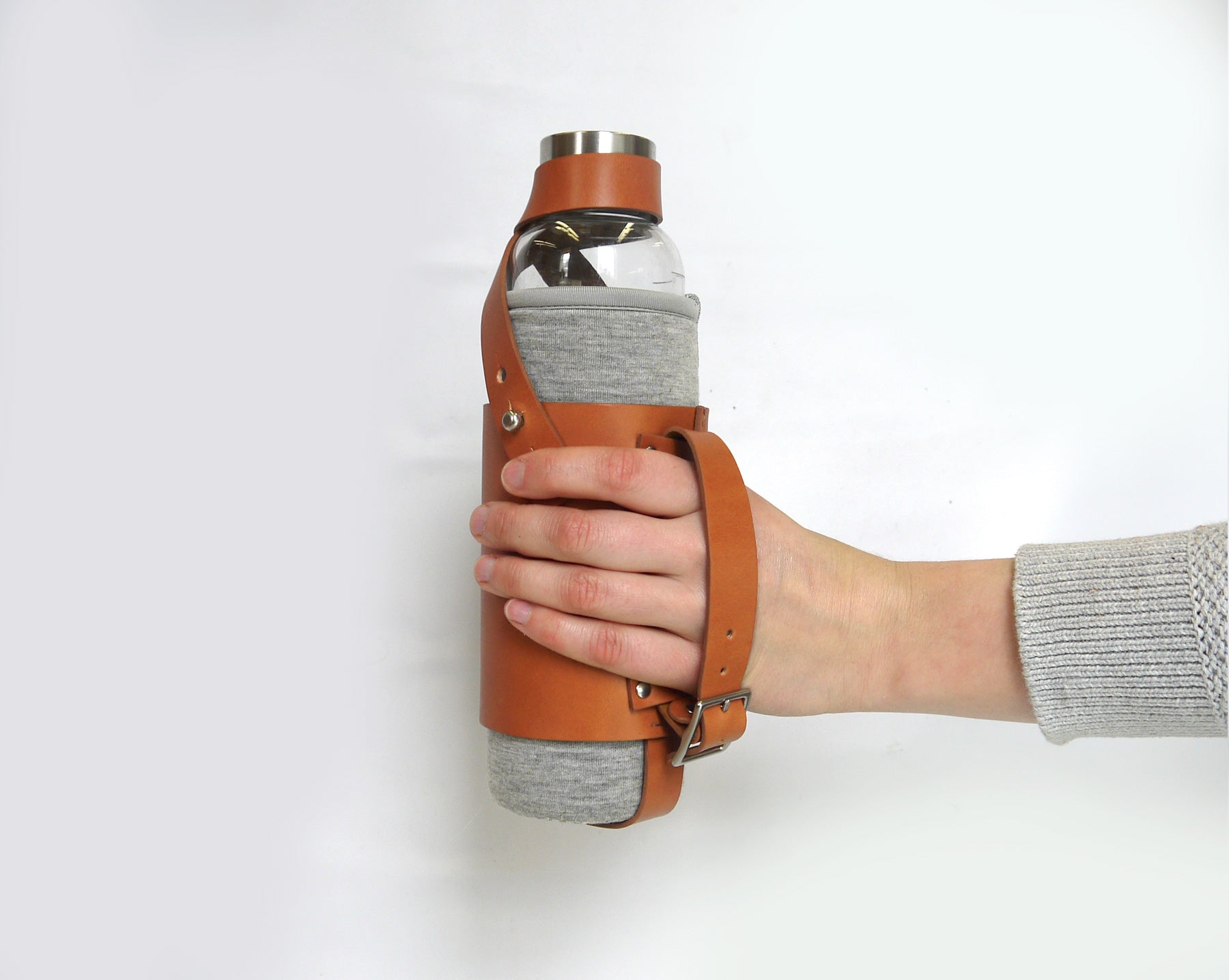 Person holding the bottle holder in english tan. 