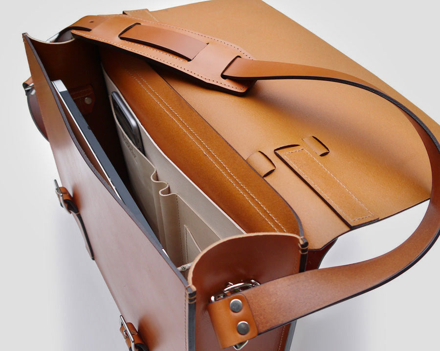 inside view of the essential that includes pen holder, phone holder, as well as other leather compartments for storage